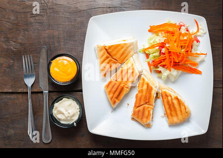 Israelische Küche, Traditionelle Naher Osten Pitabrot mit Gemüse und Sauce Salat Dressing Holztisch Hintergrund serviert. Stockfoto