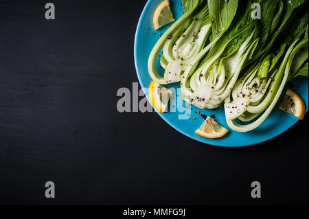 Frischer Chinakohl oder Bok Choy auf blauem Teller Stockfoto