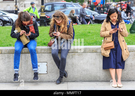 Westminster, London, 11. Mai 2018. Die Menschen fleißig Scrollen auf ihre Mobiltelefone. Trotz der bewölkt und etwas kältere Wetter, Touristen um Westminster und South Bank sind in großen Zahlen genießen Sie die Sehenswürdigkeiten der britischen Hauptstadt. Credit: Imageplotter Nachrichten und Sport/Alamy leben Nachrichten Stockfoto