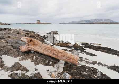 Ein Blick auf die Spiaggia della Pelosa Strand in Sardinien, Italien, in einem bewölkten Tag, Hervorhebung der Torre della Pelosa Turm im Hintergrund Stockfoto