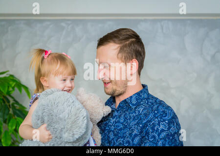 Portrait von lustigen, kleinen Mädchen und ihrem Vater zu Hause. Familie, Kindheit und Freizeit Konzept Stockfoto