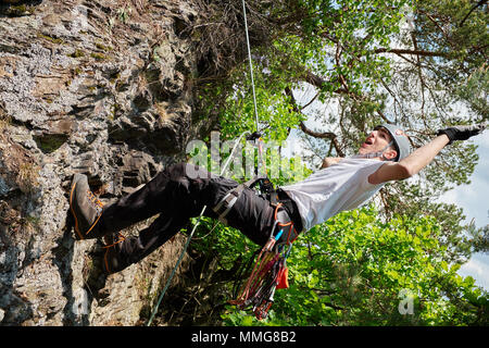 Junger Mann auf einem Felsen klettern Stockfoto
