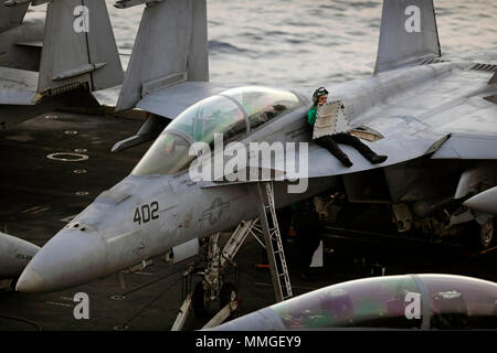 171126-N-KB 5635-1040 INDISCHER OZEAN (Nov. 26, 2017) ein matrose prüft ein Panel auf eine F/A-18F Super Hornet, zugeordnet zu den Mächtigen Würger von Strike Fighter Attack Squadron (VFA) 94, auf dem Flugdeck der Flugzeugträger USS Theodore Roosevelt (CVN 71). Theodore Roosevelt ist zur Unterstützung der Maritime Security Operations und Theater Sicherheit Zusammenarbeit bereitgestellt werden. (U.S. Marine Foto von Mass Communication Specialist 1. Klasse Michael Russell/Freigegeben) Stockfoto