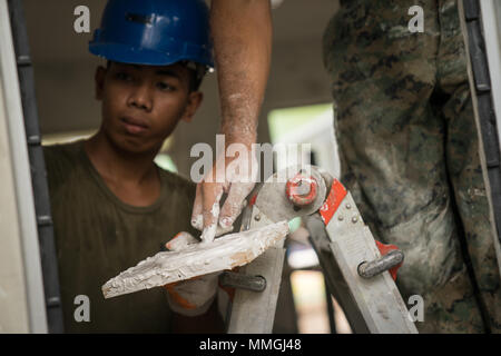 Us Marine Corps Cpl. Quentin Newton lufthutzen Farbe auf seinen Finger kleinere Bereiche durch Bürsten unberührte während der Bauarbeiten zur Unterstützung der Übung Balikatan an Calangitan Volksschule in Capas, Tarlac, Philippinen, 6. Mai 2018 zu erreichen. Newton ist ein Kampf Ingenieur mit Alpha Company, 9. Unterstützung der Techniker Bataillon, und ist eine 23-jährige gebürtige von Knoxville, Tennessee. Übung Balikatan, in seiner 34. Iteration, ist eine jährliche US-Philippinischen militärische Ausbildung Übung auf einer Vielzahl von Missionen, einschließlich humanitärer Hilfe und Katastrophenhilfe, Terrorismusbekämpfung und andere kombinierte Mil konzentriert Stockfoto