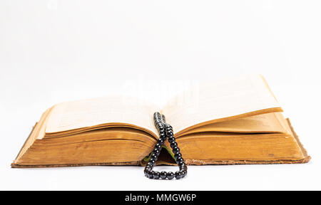 Islamische heilige Buch Koran mit Rosenkranz unter weiches Licht auf weißem Hintergrund. Ramadan Konzept. Drei Monate. Stockfoto