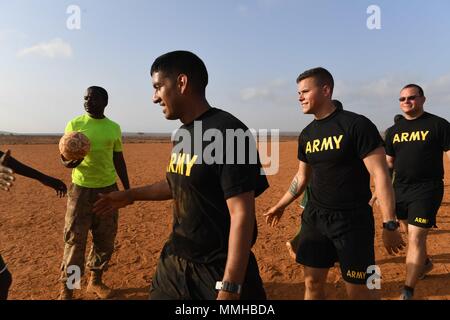 Us-Armee Infanterie Soldaten aus 10 Mountain Division und 3-144 Infanterie Regiment und die Mitglieder der Dschibuti Streitkräfte (FAD) für die schnelle Intervention Bataillon zugeordnet gegenseitig gratulieren nach einem Fußballspiel in Dschibuti Mai 10, 2018, 10. Mai 2018. Mitglieder der Rippe gehen durch einen 5-wöchigen Kurs für combatives, Waffen, und zur Bekämpfung der lebensrettenden Fähigkeiten. (U.S. Air Force Foto von Airman 1st Class Haley D. Phillips). () Stockfoto