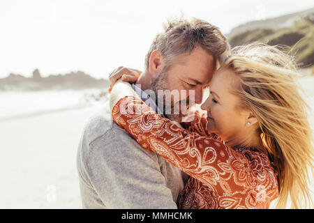 Liebevolle senior Paar einander umarmen am Strand. Reifer Mann und Frau umarmen im Freien. Stockfoto