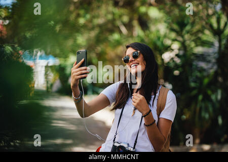 Schöne weibliche Reisende unter selfie mit Ihrem Smart Phone. Frau im Urlaub sprechen self portrait auf Ihr Mobiltelefon. Stockfoto