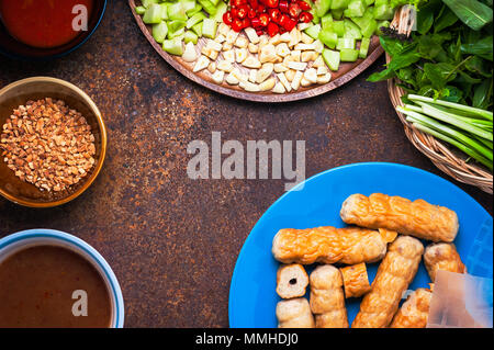 Vietnamesische Meatball Wraps (Nam Neung) mit Gemüse serviert, Würstchen auf rustikalen Tisch. Flach Stockfoto