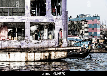 Dhaka, Bangladesh, 24. Februar 2017: Der Mensch steht im Stern von einem alten Schiff und blickt auf den Fluss Buriganga, Sadarghat Terminal in Dhaka, Bangl Stockfoto