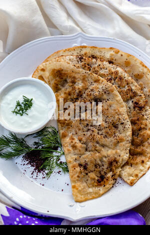 Traditionelle aserbaidschanische Küche. Qutabs Fladenbrot auf weißer Keramik Teller. Vertikale Komposition. Stockfoto