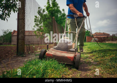 Rasenmäher schneiden grünen Gras im Hinterhof. Gartenarbeit Hintergrund. Stockfoto