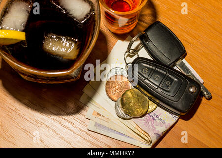Whiskey, Cocktail, das Geld und die Autoschlüssel an der Bar. Alkoholische Gläser und Autoschlüssel. Trinken Sie keinen Alkohol, während das Auto fahren. Stockfoto