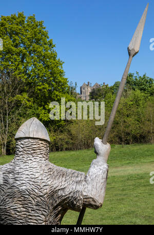 Eine aus Holz geschnitzte Skulptur des 11. Jahrhunderts Soldat mit Rüstung und Lanze in Battle Abbey in East Sussex, UK. Battle Abbey befindet sich auf dem 10. Stockfoto