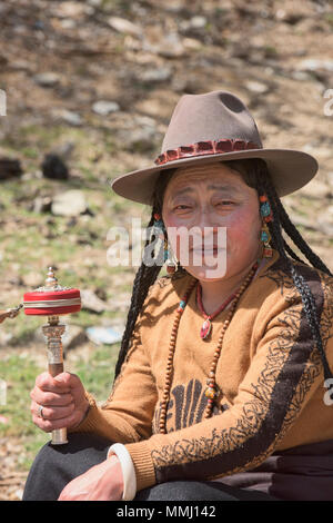 Tibetischen Pilger Spins ein Gebet Rad außerhalb des Heiligen Bakong Schrift Druckmaschine Kloster in Dege, Sichuan, China Stockfoto