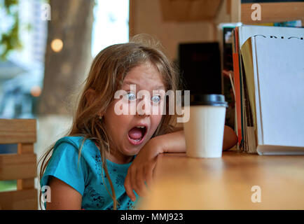 Kleines Mädchen trinken Kaffee am Tisch Stockfoto