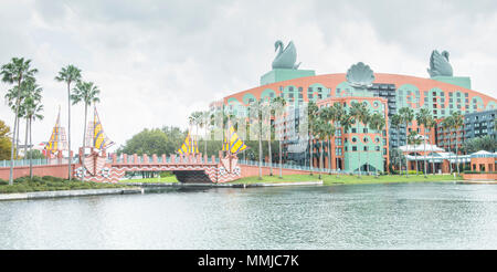 Blick auf die Deluxe Swan Hotel, von Epcot gesehen-zu-Swan-Hotel Boardwalk. Sonnig, flauschigen weißen-cloud-Tag. Boardwalk Brücke mit gelben segeln Dekorationen. Stockfoto