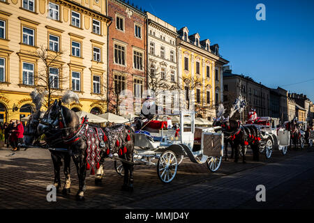 Krakau, Polen - 16. Dezember 2016. Pferdekutschen am Hauptplatz in Krakau in einem sonnigen Tag, Polen Stockfoto
