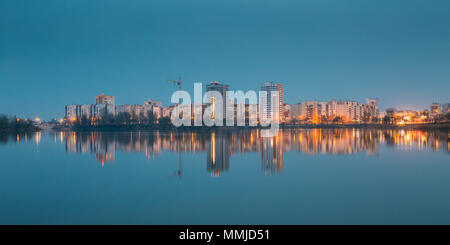 Blick auf städtische Wohngebiet mit Blick auf Stadt See oder Fluss und Park In Abend-Beleuchtung, reflektiert In der Wasseroberfläche. Frühling In Gomel-Belarus. Stockfoto