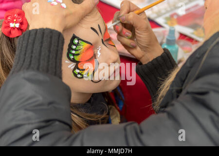 In der Nähe von Mädchen mit Schmetterling auf das Gesicht gemalt Stockfoto