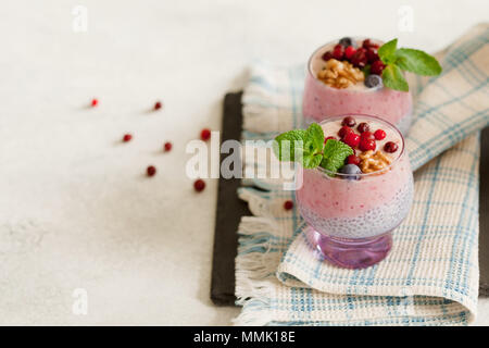 2-in-1-Chia, Banane und Berry Smoothie garniert mit frischer Minze in lila Glas, gesundes Essen Stil mit Kopie Raum Stockfoto