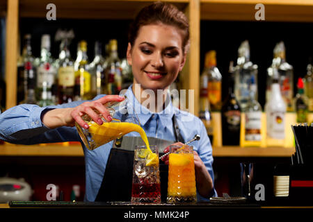 Der Barkeeper in der Bar an der Bar Cocktails vorbereitet Stockfoto