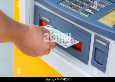 Das Geld aus dem Geldautomaten Stockfoto