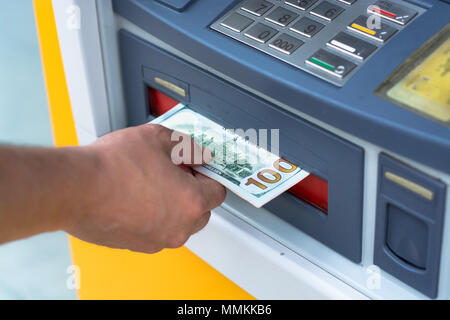 Das Geld aus dem Geldautomaten Stockfoto