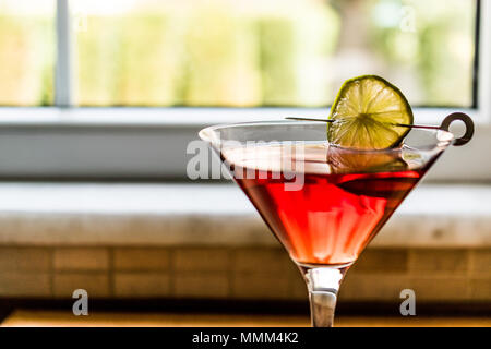 Cosmopolitan Cocktail mit Kalk auf Holz- Oberfläche. Beverage Konzept. Stockfoto