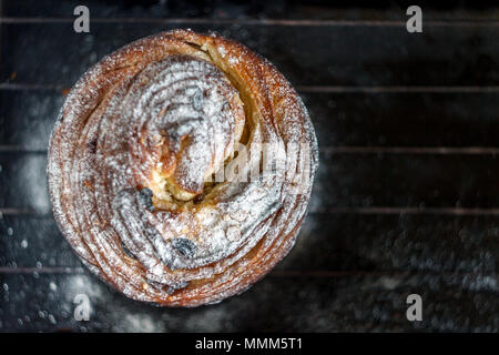 Cupcake Torte Crunch in Form einer Rolle bestreut mit Puderzucker auf einem dunklen Hintergrund und eine antike Gitter. Ostern und Weihnachten backen. Top vi. Stockfoto