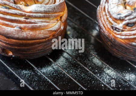 Cupcake Torte Crunch in Form einer Rolle bestreut mit Puderzucker auf einem dunklen Hintergrund und eine antike Gitter. Ostern und Weihnachten backen. Top vi. Stockfoto