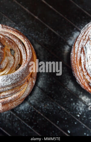 Cupcake Torte Crunch in Form einer Rolle bestreut mit Puderzucker auf einem dunklen Hintergrund und eine antike Gitter. Ostern und Weihnachten backen. Top vi. Stockfoto