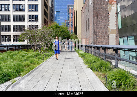 Menschen, die auf dem High Line Park in New York spazieren. Der Park hat zu raschen Veränderungen im Chelsea-Viertel geführt und wurde zu einem Werkzeug der Gentrifizierung Stockfoto