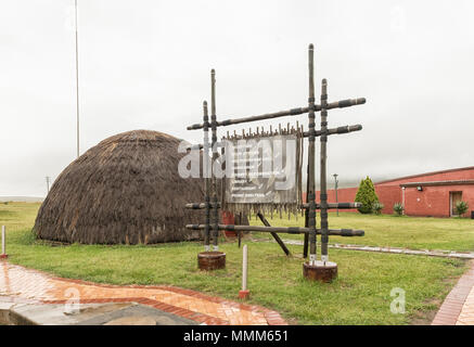 BLOEDRIVIER, SÜDAFRIKA - 22. MÄRZ 2018: Eine Infotafel und Zulu Hütte auf der Ncome Zulu Heritage Museum bei Bloedrivier (Blut), wo der Fluss Stockfoto