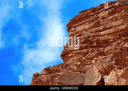 Cut Monolith in der Wüste das Naturschutzgebiet Wadi Rum, in den Himmel mit einem Flugzeug, dass Kondensstreifen erzeugt, Jordanien, umherzulaufen Osten Stockfoto