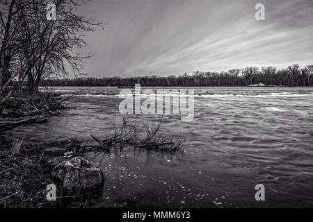 Ein schwarz-weiß Foto einer Kaskade entlang der Maumee River im Nordwesten von Ohio im Frühjahr Tauwetter. Stockfoto