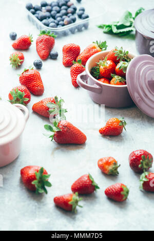 Sommer Obst Hintergrund, Blick von oben auf die Beeren, smoothie Zutaten, in Keramik farbige Cocotte, Heidelbeeren, Erdbeeren, Himbeeren, flach Stockfoto