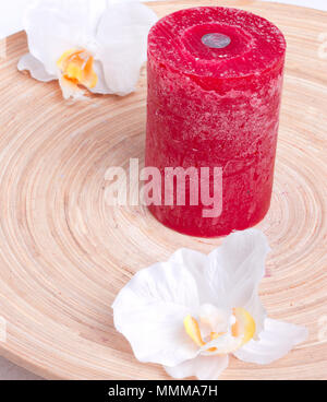 Rote Kerze mit Blumen auf Holzplatte Stockfoto