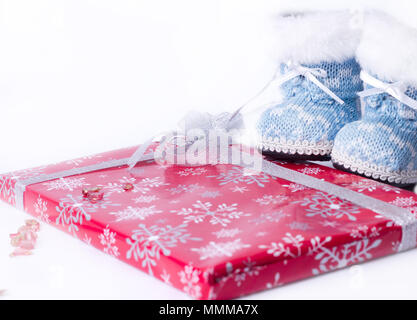 Weihnachten Winter Stiefel um ein Geschenk auf weißem Hintergrund gewickelt Stockfoto