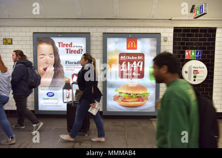Menschen gehen vorbei Werbetafeln Förderung McDonalds BBQ Chicken Burger in der Notting Hill U-Bahn Station im Zentrum von London. Junk Food ad Stockfoto