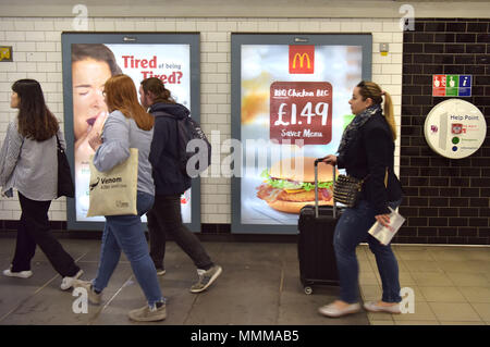 Menschen gehen vorbei Werbetafeln Förderung McDonalds BBQ Chicken Burger in der Notting Hill U-Bahn Station im Zentrum von London. Junk Food ad Stockfoto