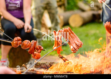 Grillen Würstchen über einem Lagerfeuer im Wald. Urlaub und Sommer Camping in der Landschaft. Beltaine Nacht in der Tschechischen Republik. Mai Tag celebrat Stockfoto