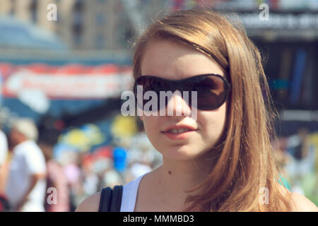 Frau mit Sonnenbrille in der Menge auf dem Hintergrund Stockfoto