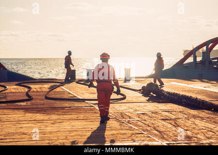 Anchor Handling Tug Supply AHTS die Schiffsbesatzung Vorbereitung Schiff für statische tow Tanker anheben. Ozean tug Job. 3 AB und Bootsmann auf dem Deck. Gute Teamarbeit Stockfoto