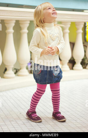 Mädchen 3 Jahre alt in einer Jeans Rock und rosa Strumpfhose ist Stockfoto