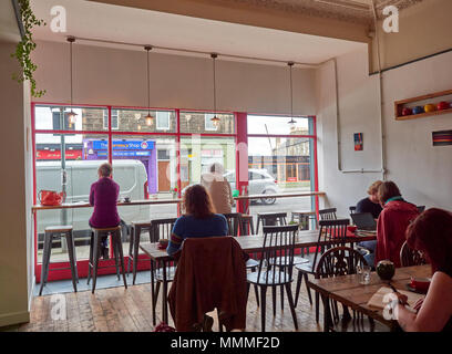 Cafe Szene am Red Kite Café in Edinburgh, mit Menschen an Tischen sitzen, Kaffee trinken und arbeiten an ihren Laptops oder Zeitschriften. Edinburgh, Stockfoto