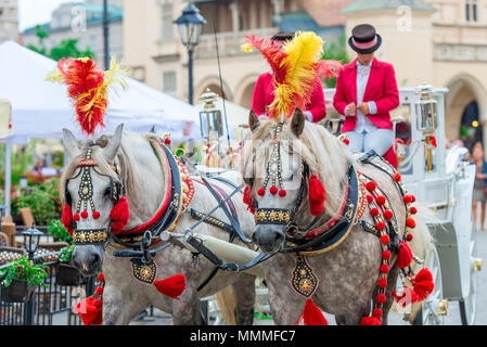 Wagen mit Pferden für Touristen auf dem Marktplatz von Krakau, Polen Stockfoto