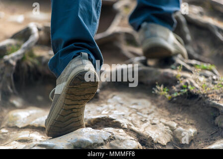 Die touristische steigt auf den Berg, seine Beine close-up auf den Steinen Stockfoto