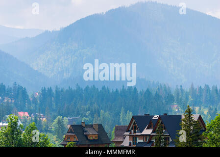 Dorf am Fuße der Berge von Wald umgeben, in den frühen Morgenstunden Stockfoto