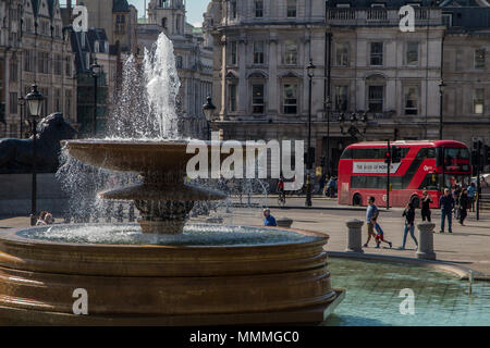 Ein roter Doppeldeckerbus vorbei am Brunnen am Trafalgar Square Stockfoto